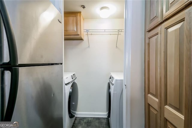 clothes washing area with laundry area, washer and clothes dryer, and baseboards