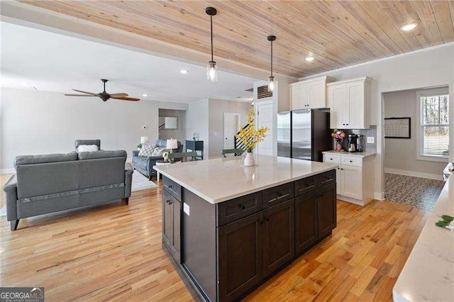 kitchen featuring white cabinets, wooden ceiling, light wood-style flooring, freestanding refrigerator, and light countertops