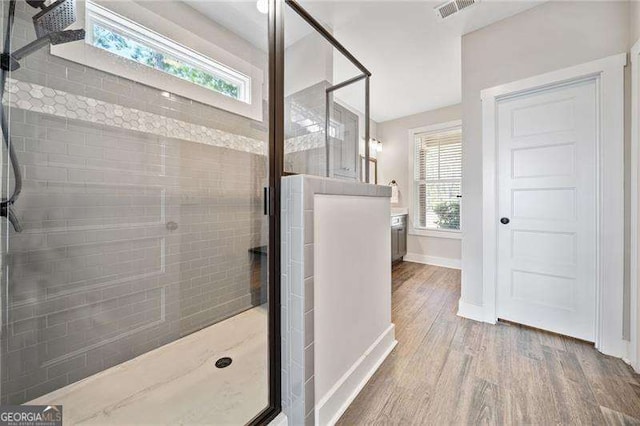 full bath with visible vents, a shower stall, baseboards, and wood finished floors