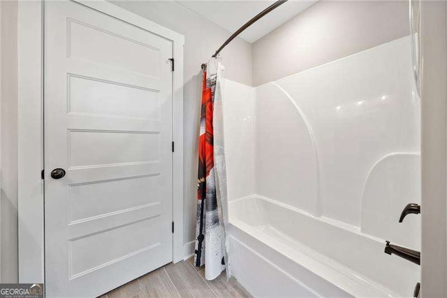 bathroom featuring shower / tub combo and wood finished floors