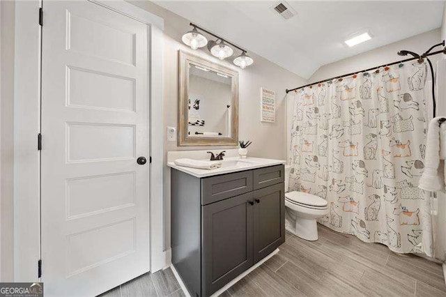 full bathroom with visible vents, toilet, curtained shower, wood tiled floor, and vanity