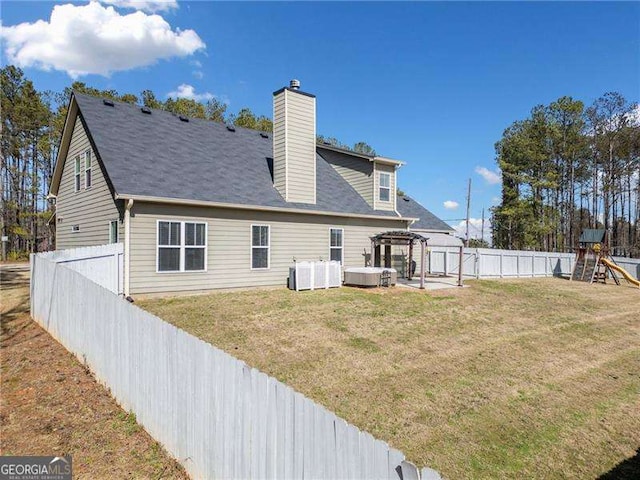 rear view of property with a playground, a lawn, and a fenced backyard