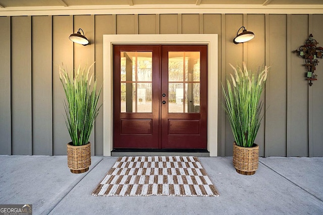 view of exterior entry featuring french doors and board and batten siding