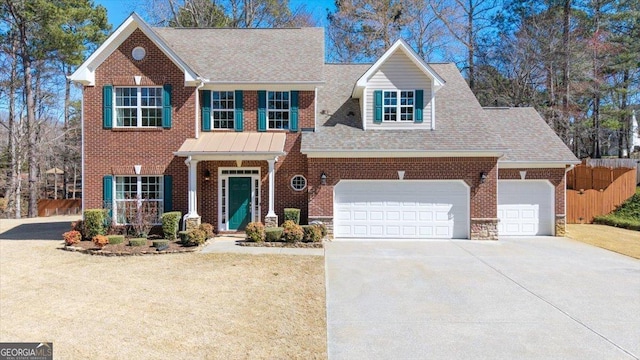 view of front of home with a garage, driveway, fence, and brick siding