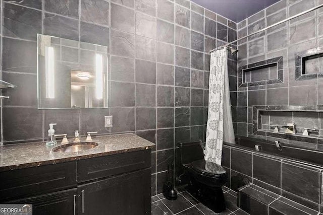 full bathroom with tiled shower / bath, tile walls, toilet, and vanity