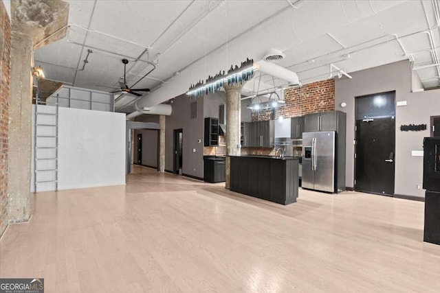 kitchen with open floor plan, visible vents, a towering ceiling, and stainless steel fridge with ice dispenser