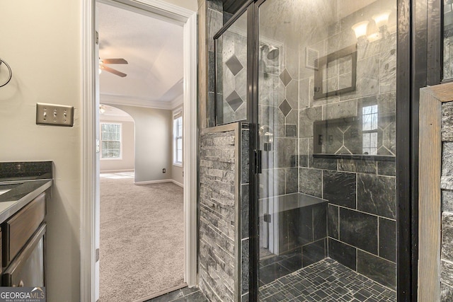 bathroom with ornamental molding, a stall shower, a ceiling fan, vanity, and baseboards