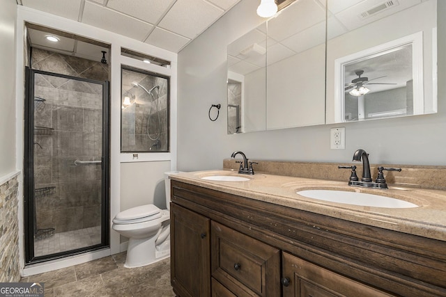 bathroom featuring visible vents, a sink, a shower stall, and double vanity