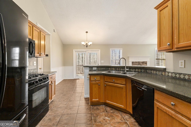 kitchen with hanging light fixtures, black appliances, brown cabinets, and a sink