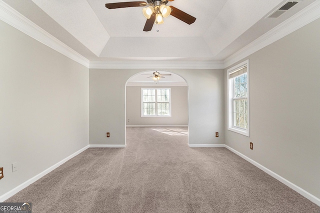 empty room with a tray ceiling, visible vents, and baseboards