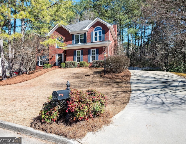 view of front facade featuring driveway and brick siding