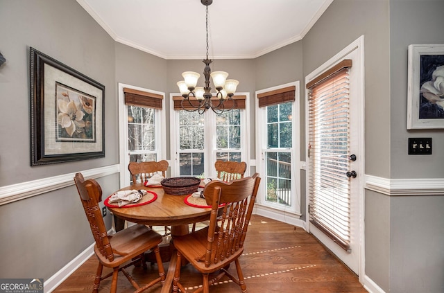 dining space with an inviting chandelier, baseboards, dark wood-style floors, and crown molding