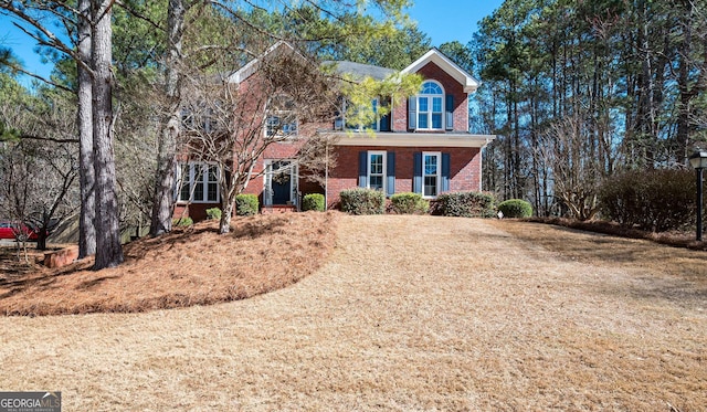 colonial house featuring brick siding