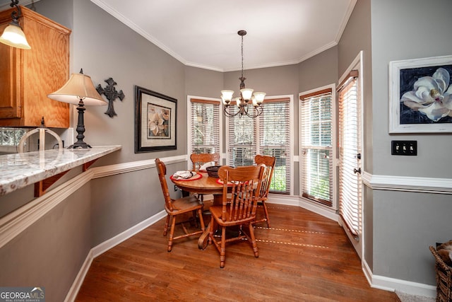 dining area with a notable chandelier, crown molding, baseboards, and dark wood-style flooring