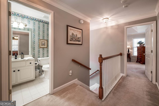 corridor featuring light carpet, baseboards, ornamental molding, an upstairs landing, and a sink