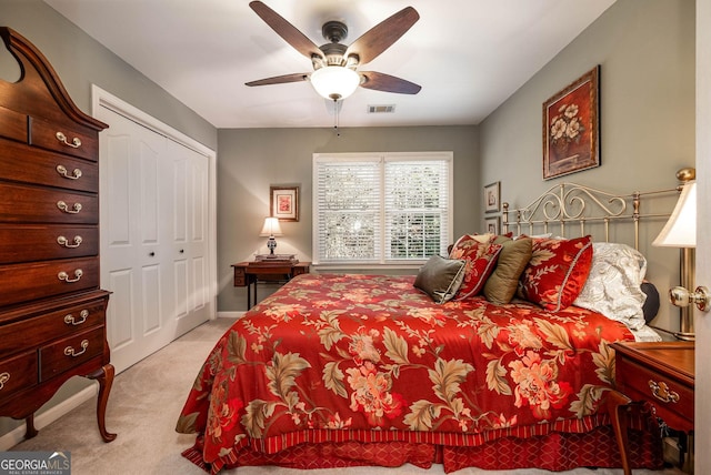 bedroom with ceiling fan, a closet, visible vents, and light colored carpet