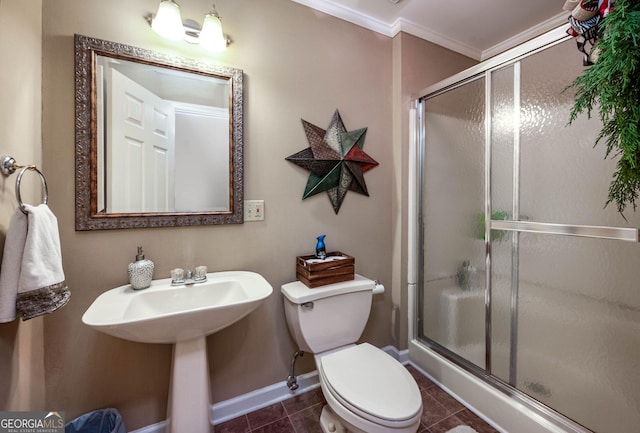 bathroom with ornamental molding, a shower stall, toilet, and tile patterned floors