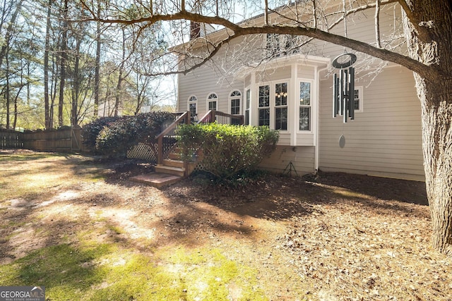 view of side of property featuring fence and a deck