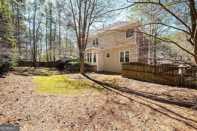 rear view of house with a fenced backyard