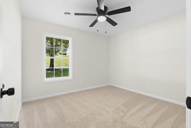 carpeted empty room featuring visible vents, ceiling fan, and baseboards