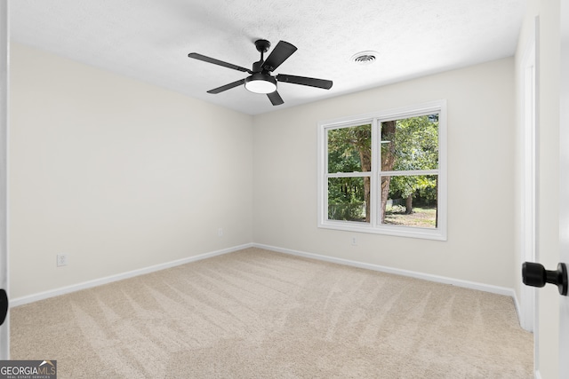 spare room featuring light colored carpet, visible vents, and baseboards