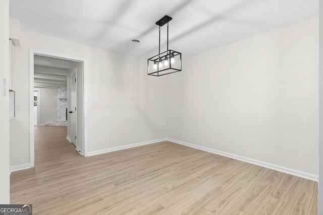 unfurnished dining area with light wood-style floors and baseboards