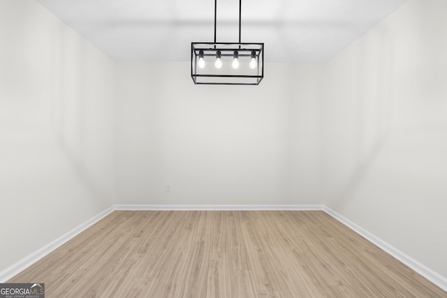 unfurnished dining area with light wood-type flooring and baseboards