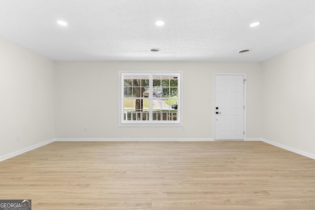 spare room featuring recessed lighting, light wood-type flooring, visible vents, and baseboards