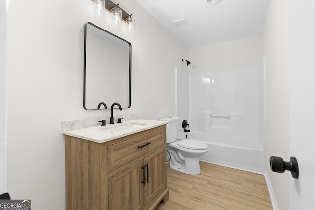 bathroom featuring toilet, bathing tub / shower combination, wood finished floors, and vanity