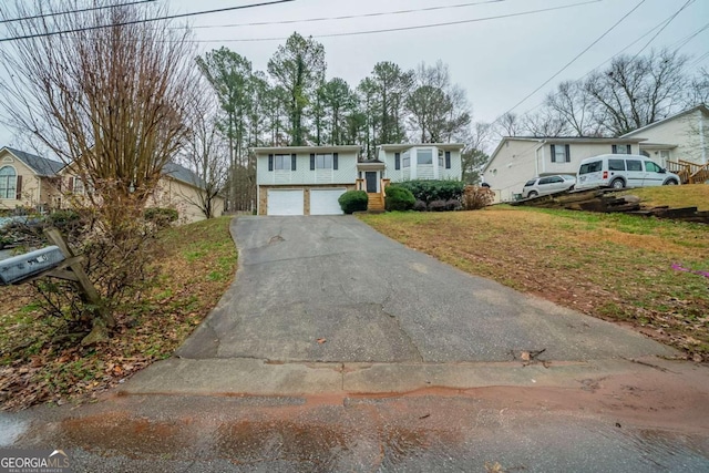 split foyer home featuring a garage, a front yard, and driveway