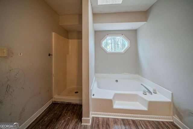 full bathroom with a garden tub, baseboards, and wood finished floors