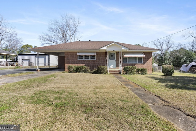 view of front of house with a carport, a front yard, brick siding, and aphalt driveway