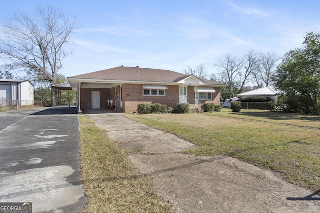 view of front facade featuring brick siding, aphalt driveway, a front lawn, and an attached carport