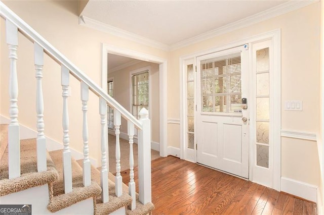 entrance foyer with baseboards, stairway, wood finished floors, and crown molding