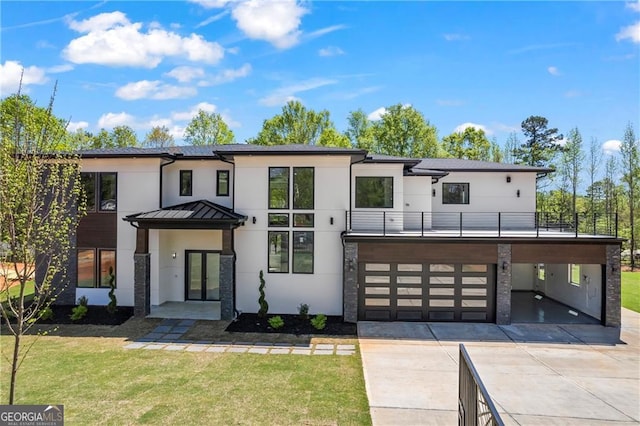 modern home featuring concrete driveway, stucco siding, a front lawn, and a garage