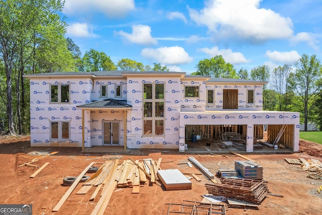 rear view of property with a standing seam roof, metal roof, and stucco siding