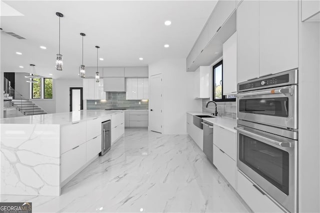 kitchen with modern cabinets, stainless steel appliances, decorative backsplash, recessed lighting, and a sink