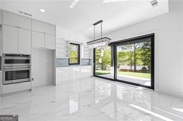 kitchen featuring double oven, light marble finish flooring, white cabinetry, a chandelier, and recessed lighting