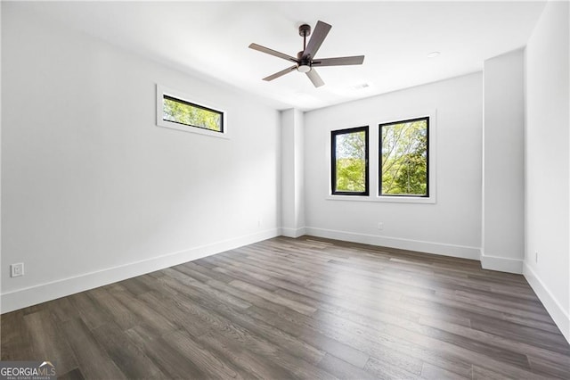unfurnished room featuring dark wood-style floors, ceiling fan, and baseboards