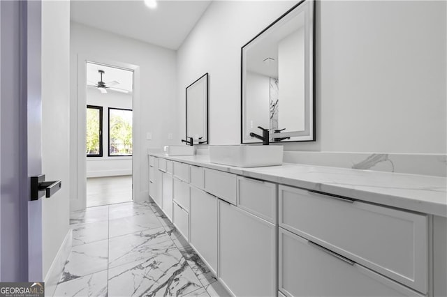 bathroom with marble finish flooring, double vanity, a ceiling fan, baseboards, and recessed lighting