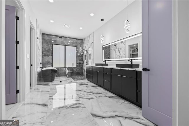 bathroom featuring marble tiled flooring, a freestanding tub, double vanity, and recessed lighting