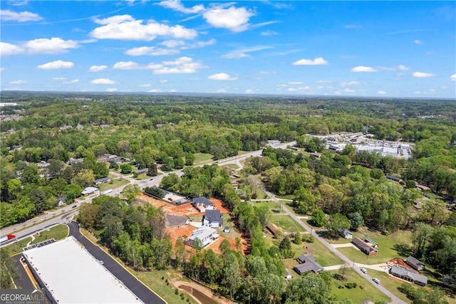 aerial view of property and surrounding area featuring a forest