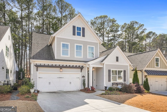 view of front of home with a garage, concrete driveway, a shingled roof, and board and batten siding