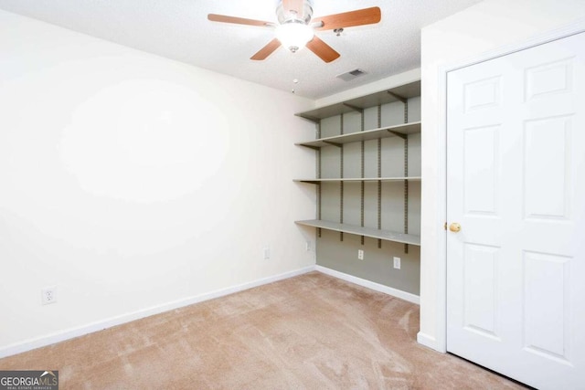 empty room with light carpet, baseboards, visible vents, and a ceiling fan