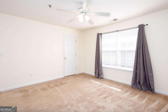 unfurnished room featuring visible vents, ceiling fan, light carpet, and baseboards