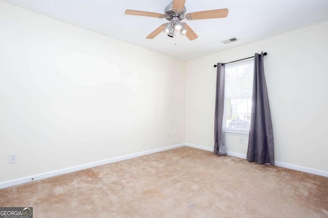 unfurnished room featuring light carpet, ceiling fan, visible vents, and baseboards