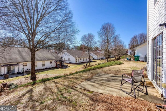 view of yard featuring a residential view, a playground, and a patio