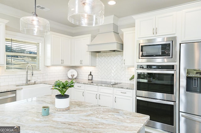 kitchen featuring white cabinets, stainless steel appliances, and hanging light fixtures