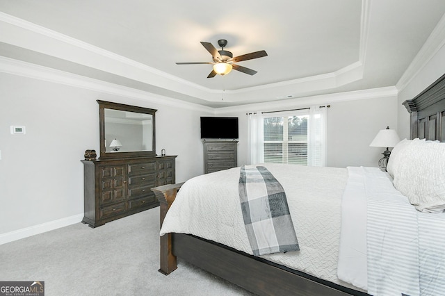 bedroom featuring crown molding, a raised ceiling, light colored carpet, ceiling fan, and baseboards