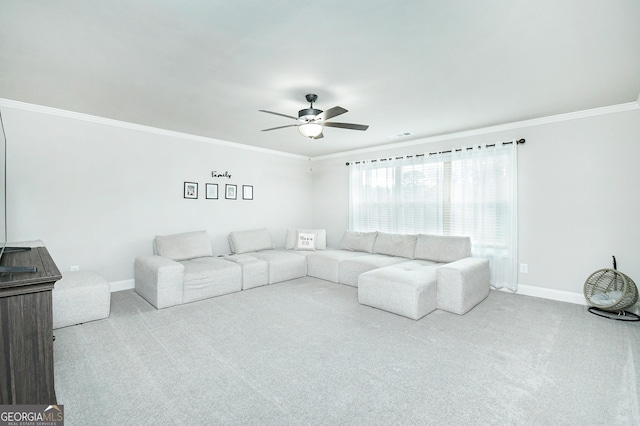 living area featuring light carpet, ornamental molding, a ceiling fan, and baseboards